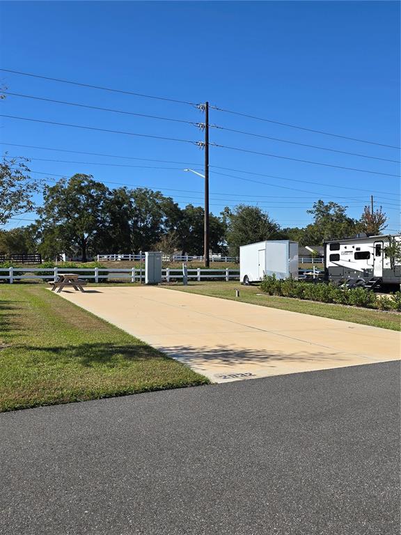 A paved RV site features a picnic table, utility hookups, and a white fence — 2932 NW 43RD COURT UNIT 421, OCALA, FL