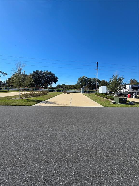 A paved RV pad sits adjacent to a road with a white fence in the background — 2932 NW 43RD COURT UNIT 421, OCALA, FL