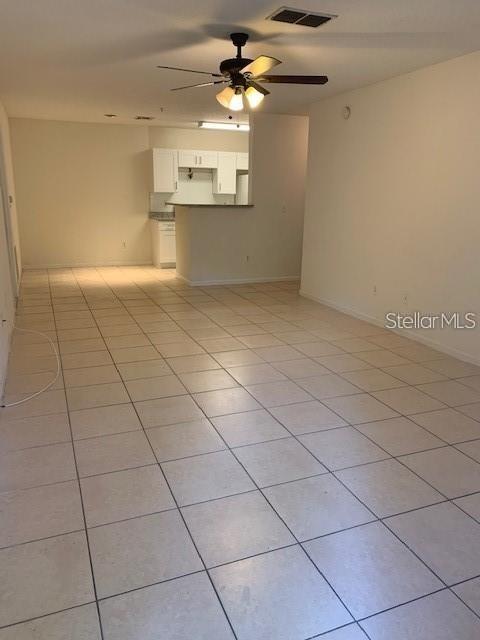 An open-concept living area with light-colored floor tiles and a ceiling fan — 4308 S KIRKMAN ROAD UNIT 1713, ORLANDO, FL