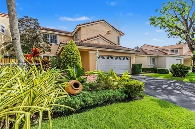 A two-story house with a tan stucco exterior, a tile roof, and a two-car garage — 15033 SW 110th Ter, Miami FL 33196, MIAMI, FL