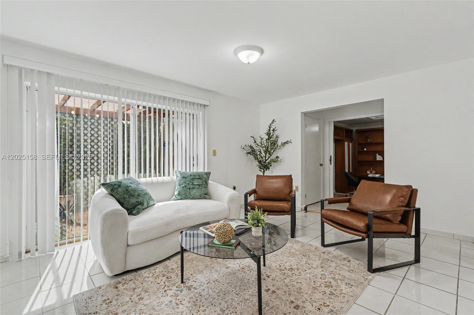 A living room features a white sofa, two brown leather chairs, and a glass coffee table — 15033 SW 110th Ter, Miami FL 33196, MIAMI, FL