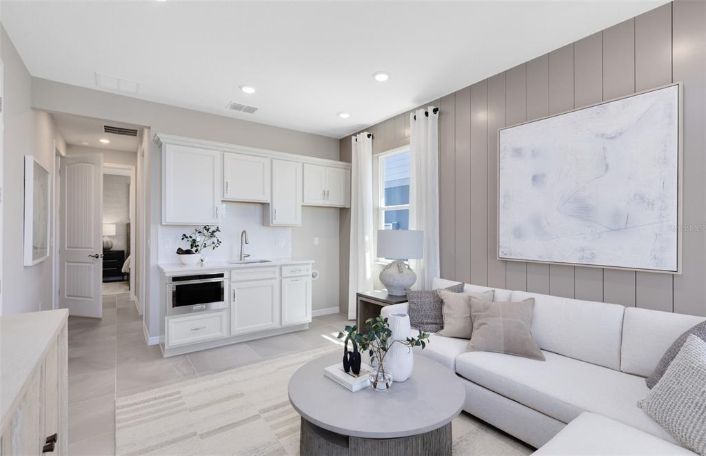 A living room features a kitchenette with white cabinets, a sofa, and a coffee table — 2562 WINTER SKY STREET, KISSIMMEE, FL