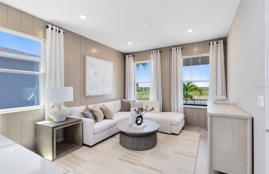 A living room features a white sectional sofa, a round coffee table, and wood-paneled walls — 2562 WINTER SKY STREET, KISSIMMEE, FL