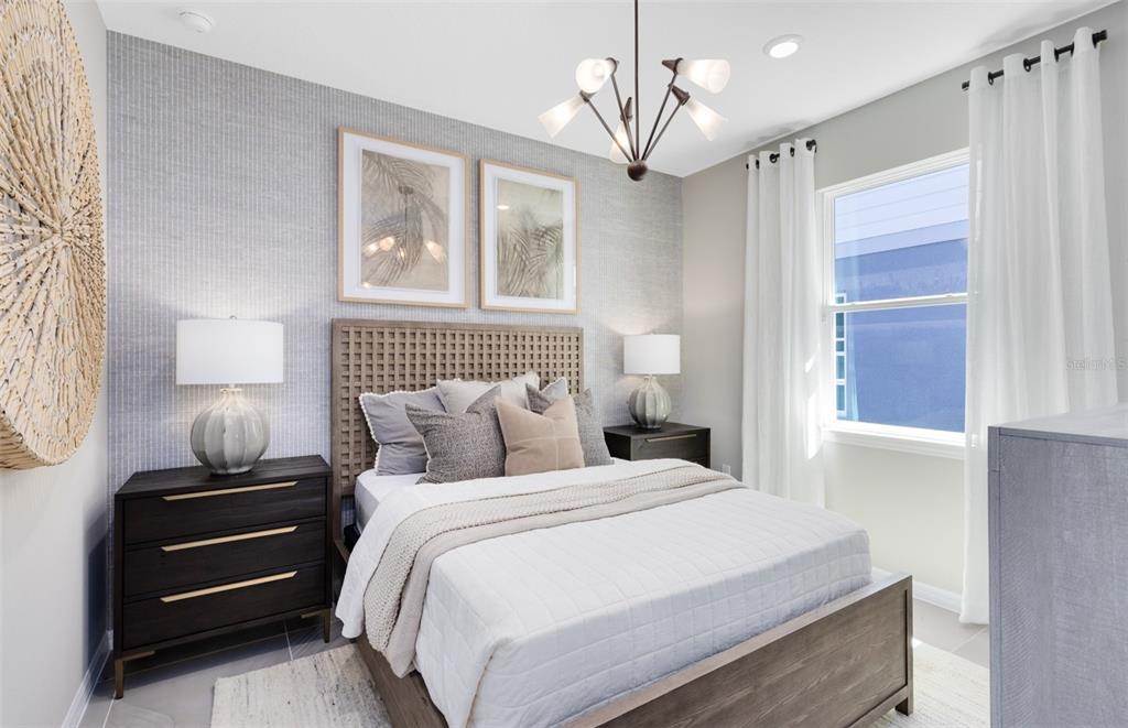 A bedroom features a wooden bed frame, textured wallpaper, two nightstands, and a modern chandelier — 2562 WINTER SKY STREET, KISSIMMEE, FL