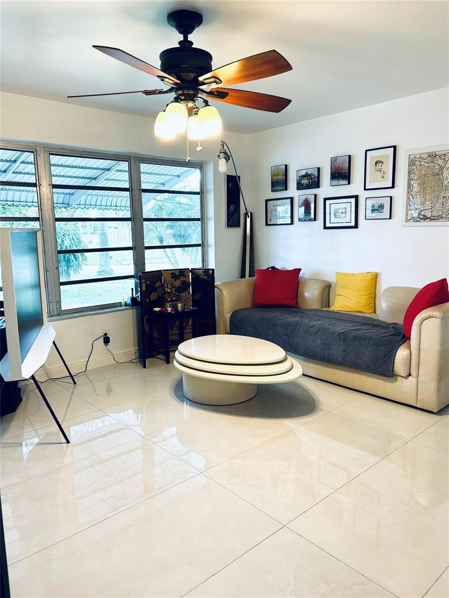 A living room features a beige sofa, a tiered coffee table, and a ceiling fan — 1521 NW 62nd Terrace, Margate FL 33063, MARGATE, FL
