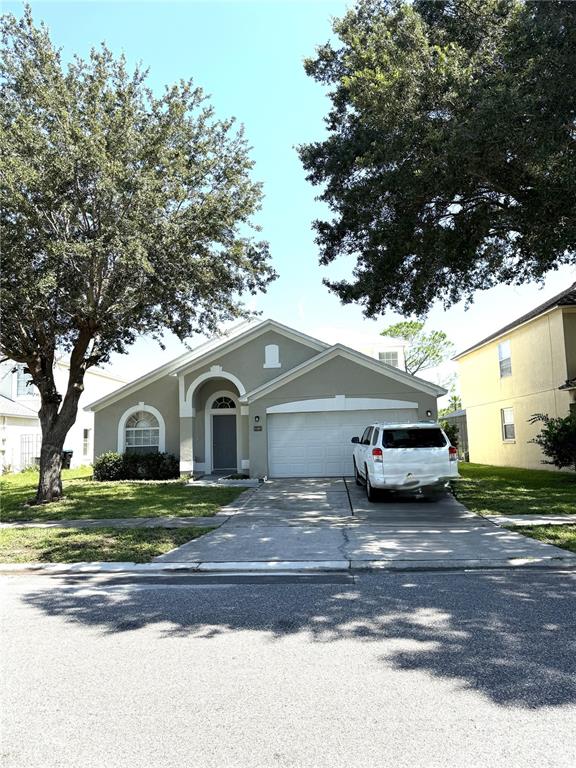 A single-story house with a white garage, gray exterior, and a driveway with a car — 4207 ANDOVER CAY BOULEVARD, ORLANDO, FL