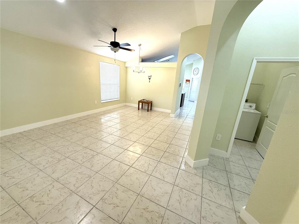An open-concept living area features light-colored tile flooring, a ceiling fan, and an arched doorway — 4207 ANDOVER CAY BOULEVARD, ORLANDO, FL