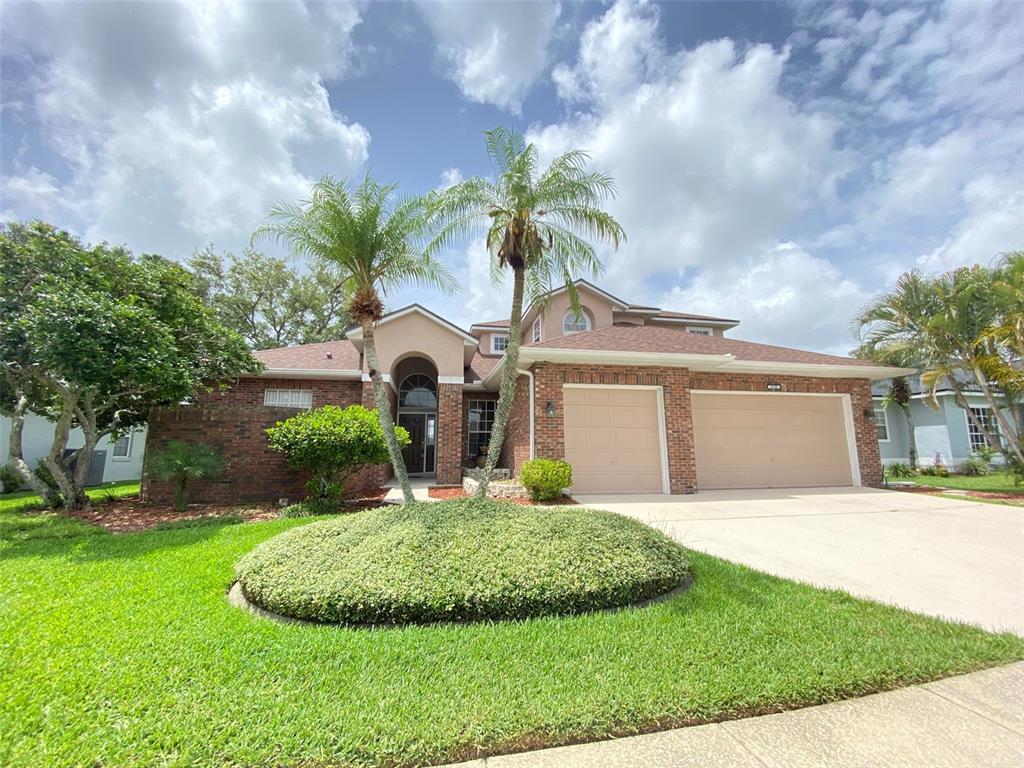 A one-story brick house with a three-car garage and two palm trees in the yard — 3708 MOLONA DRIVE, ORLANDO, FL