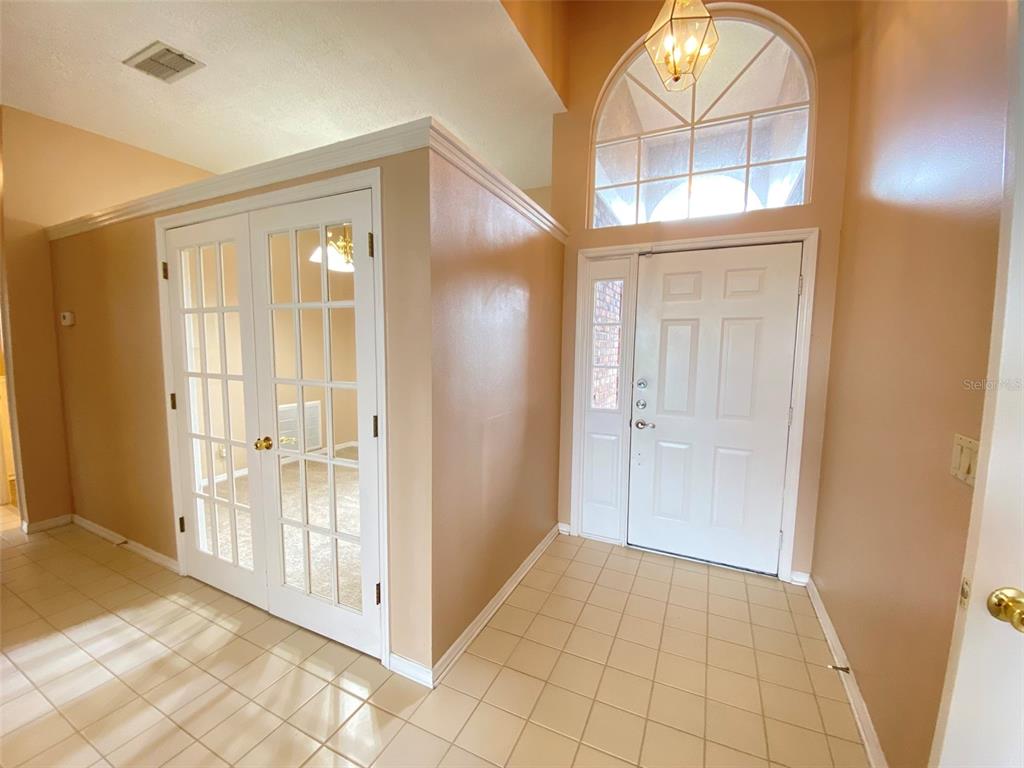 An entryway features tiled flooring, a white front door with sidelights, and French doors — 3708 MOLONA DRIVE, ORLANDO, FL