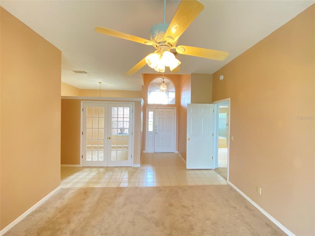 A carpeted room features a ceiling fan, tiled entryway, and white French doors — 3708 MOLONA DRIVE, ORLANDO, FL