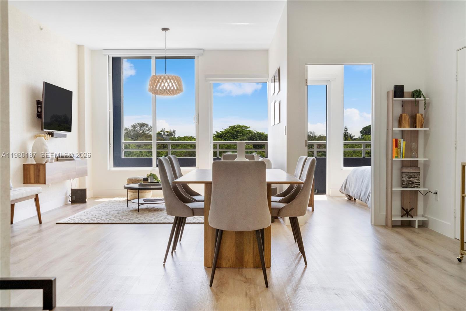 A dining area with a wooden table and chairs sits adjacent to a living space — 3250 Grand Ave # 507, Miami FL 33133, MIAMI, FL
