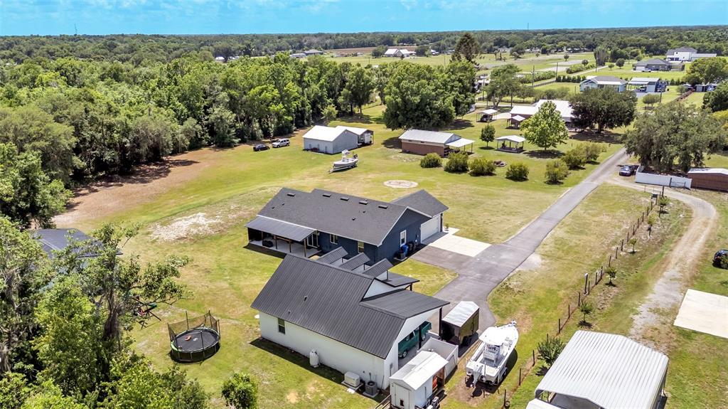 An aerial view shows two houses with dark roofs, a driveway, and several outbuildings on land — 3111 BELL BEGINNINGS COURT, PLANT CITY, FL