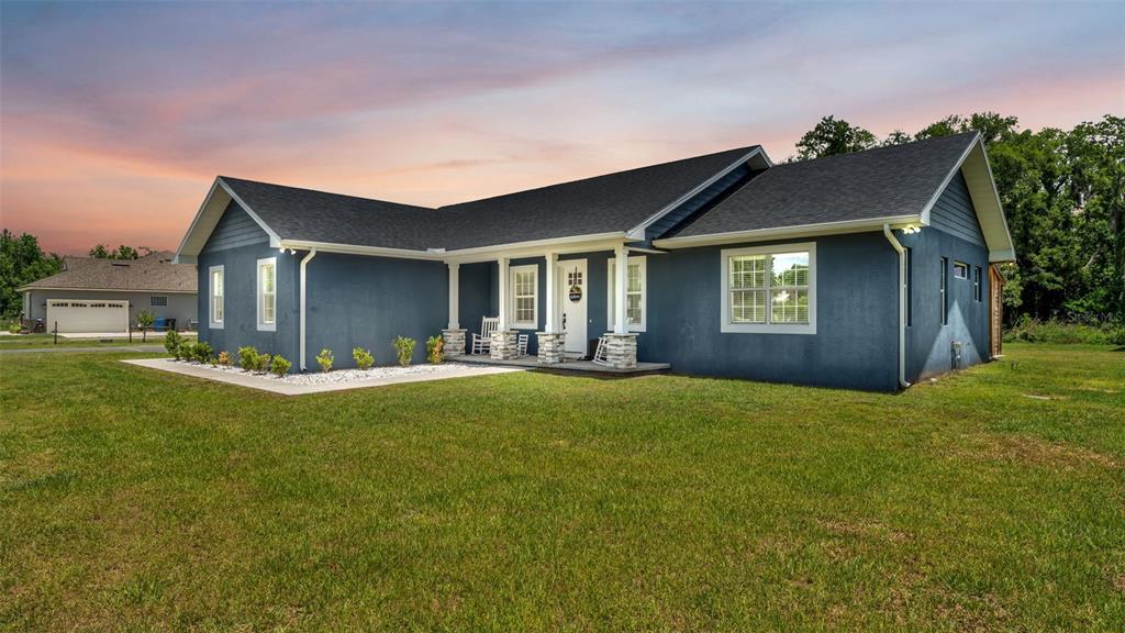 A blue single-story house with a stone-accented porch and a large front lawn — 3111 BELL BEGINNINGS COURT, PLANT CITY, FL