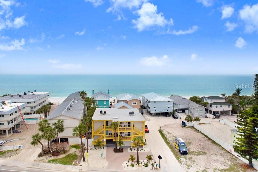 An aerial view of a yellow multi-story building near a sandy beach and the ocean — 708 GULF BOULEVARD UNIT A, INDIAN ROCKS BEACH, FL
