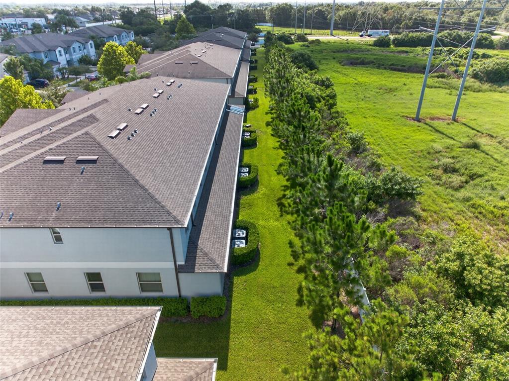 An aerial view shows the side of a multi-story apartment building next to trees — 7617 GINGER LILY COURT, TAMPA, FL
