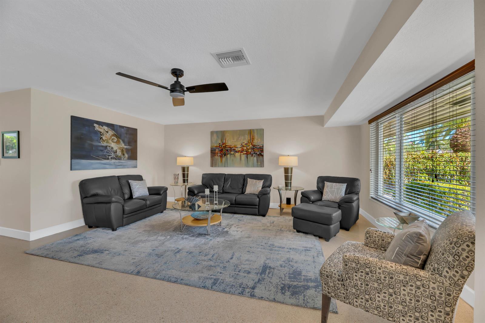 A living room features dark leather furniture, a patterned armchair, and a large area rug — 2401 NE 17th Terrace, Wilton Manors FL 33305, WILTON MANORS, FL