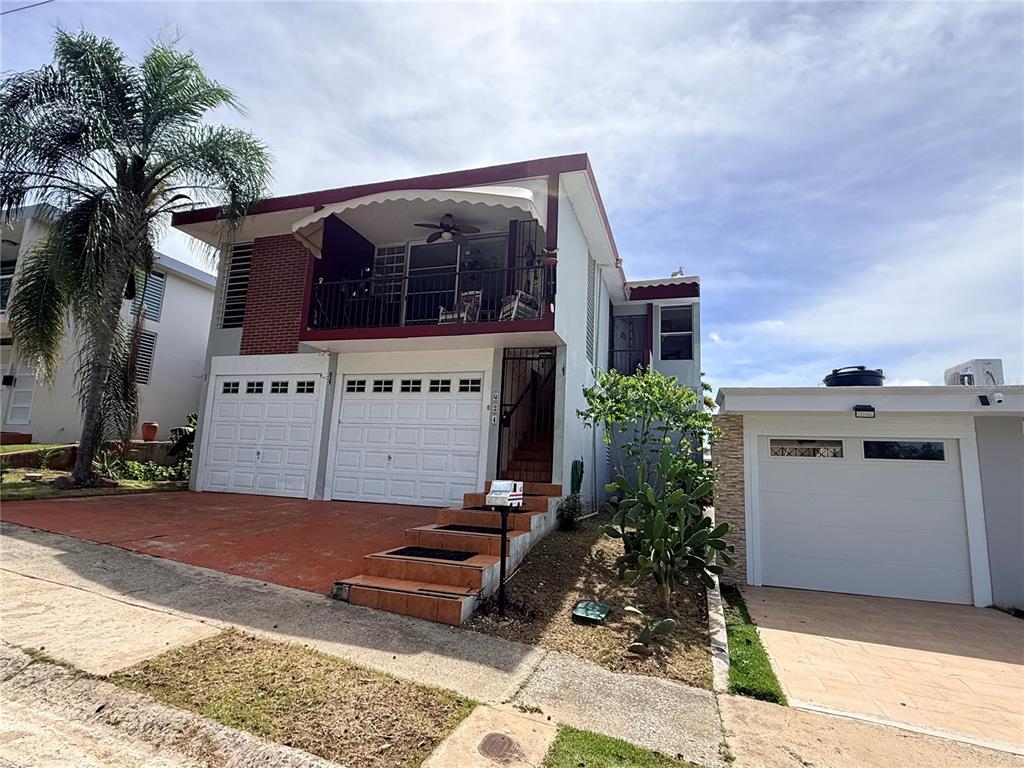 A two-story house with a balcony, two garage doors, and a separate side garage — Q24 Calle 12 CALLE ANTONIA SÁEZ, URB BORINQUEN, CABO ROJO, PR