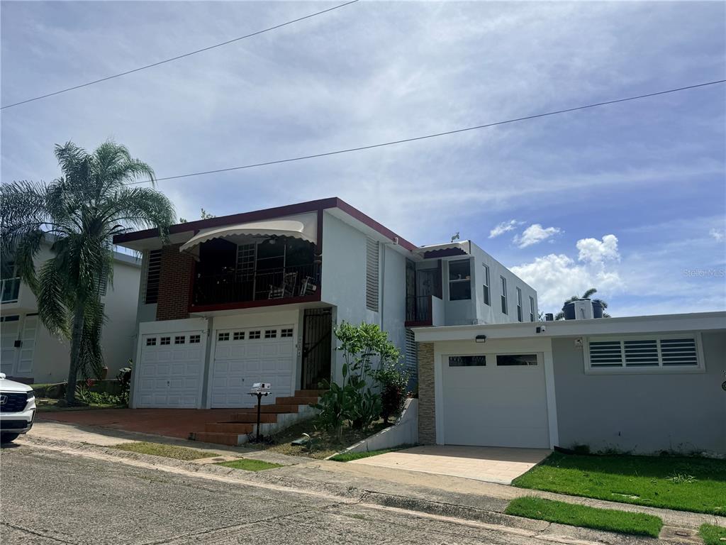 A two-story house with a balcony, two garage doors, and a separate attached garage — Q24 Calle 12 CALLE ANTONIA SÁEZ, URB BORINQUEN, CABO ROJO, PR