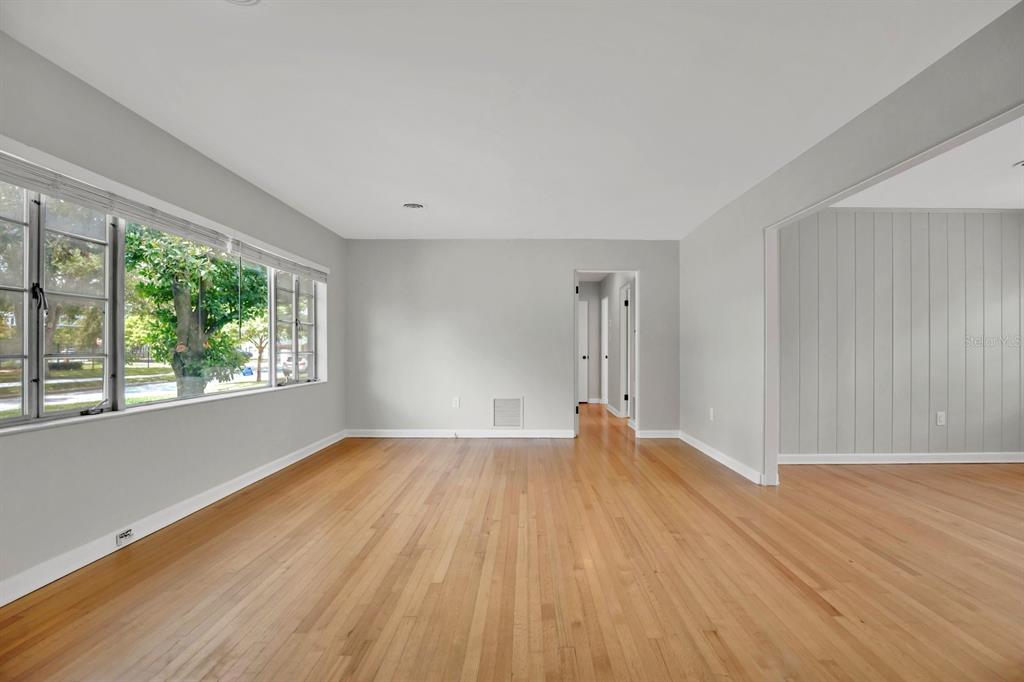 An empty room with light gray walls, hardwood floors, and a large window — 1427 BRYN MAWR STREET, ORLANDO, FL