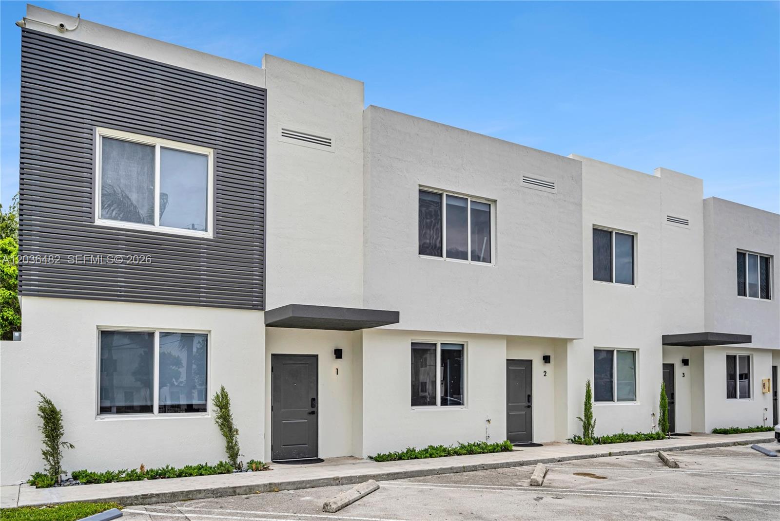 A row of modern two-story townhouses with white stucco walls and dark gray accents — 170 NW 158th St # 2, Miami FL 33169, MIAMI, FL