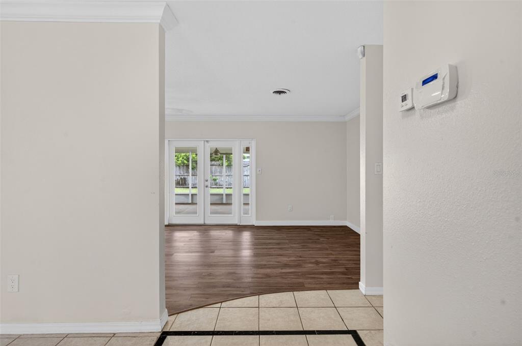 A view from a tiled entryway into a living room with wood-look flooring and doors — 2715 PRINCE JOHN ROAD, WINTER PARK, FL