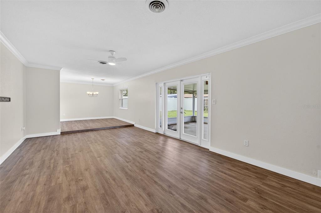 A living room with wood-look flooring, a ceiling fan, and glass doors to a patio — 2715 PRINCE JOHN ROAD, WINTER PARK, FL