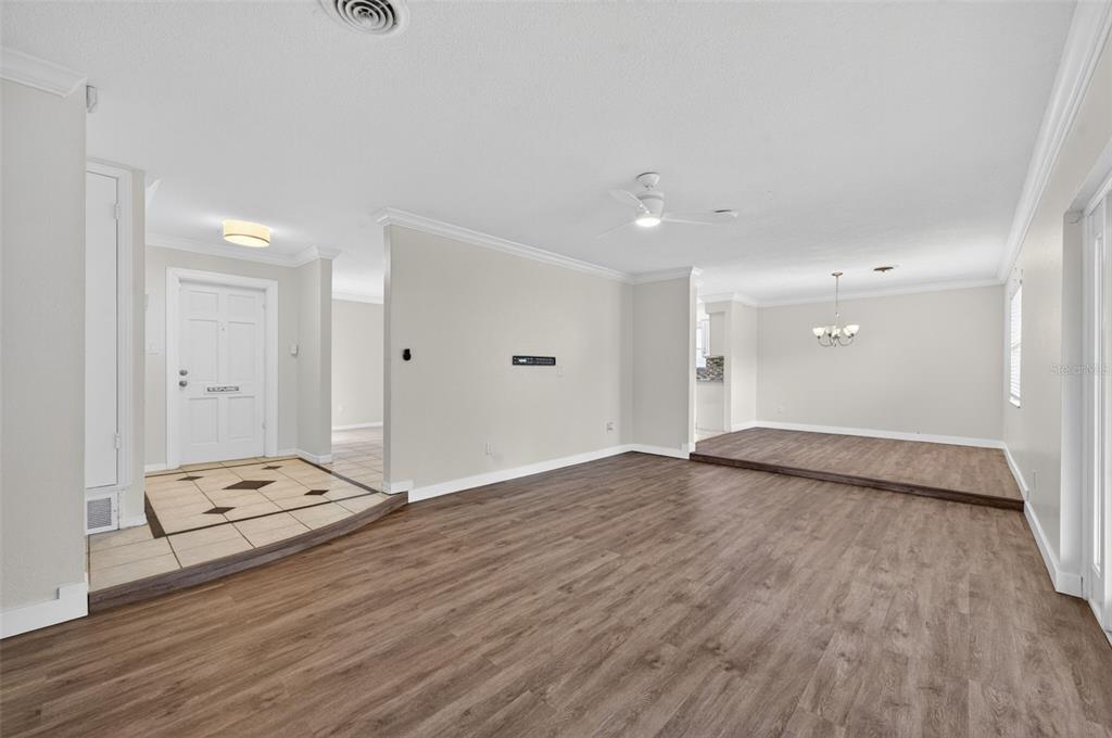 A living room with wood-look flooring, a tiled entryway, and a raised dining area — 2715 PRINCE JOHN ROAD, WINTER PARK, FL