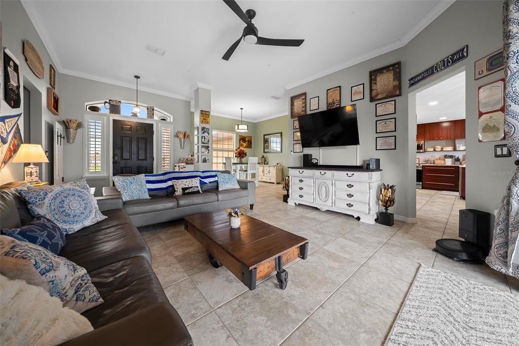 An entryway features a black front door, white shutters, a wooden bench, and a storage cabinet — 6145 SE 96TH STREET, BELLEVIEW, FL