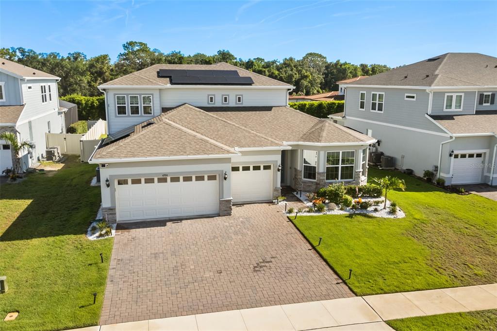 An aerial view of a two-story house with a paved driveway and solar panels — 4708 WEATHERBELL ROAD, WINTER GARDEN, FL