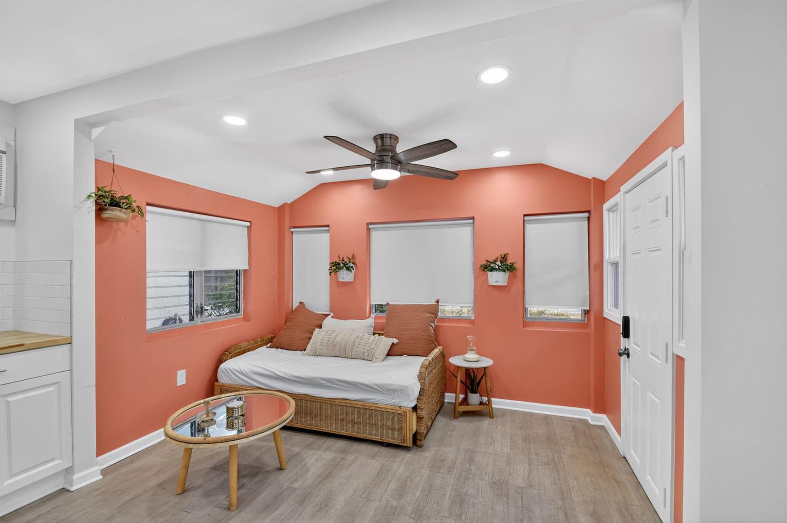 A living area features coral walls, a daybed, a coffee table, and a ceiling fan — 306 N J Street, FL 33460, FL