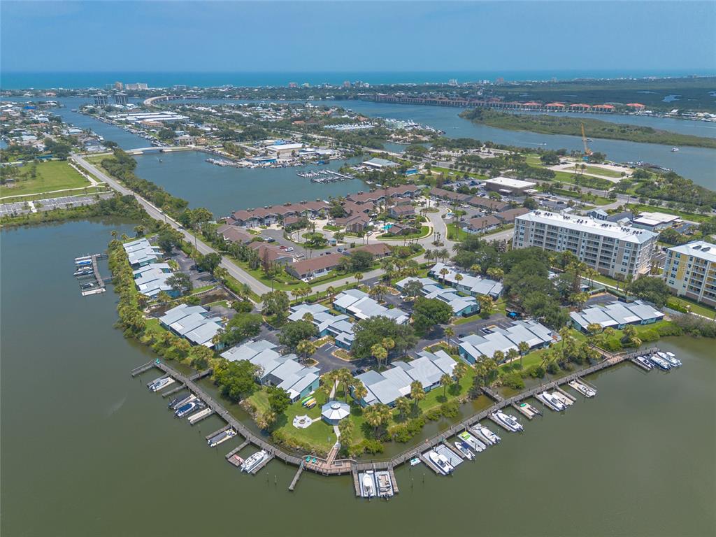 An aerial view of a waterfront residential complex with boat docks and surrounding waterways — 76 HEATHER POINT COURT, NEW SMYRNA BEACH, FL