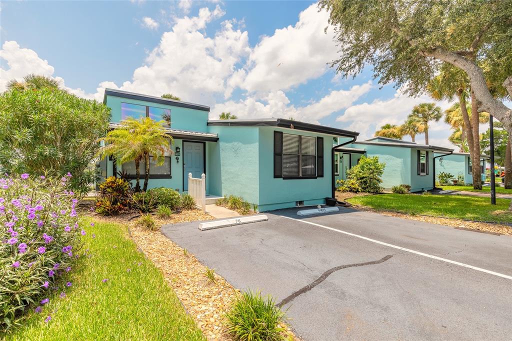 A light blue, single-story residential building with a paved parking space in front — 76 HEATHER POINT COURT, NEW SMYRNA BEACH, FL