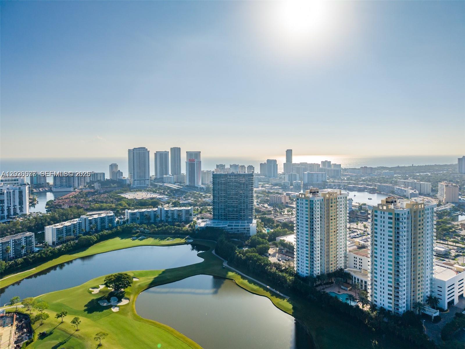 An aerial view shows a golf course with ponds in front of a city skyline — 1745 E Hallandale Beach Blvd # 2104W, Hallandale Beach FL 33009, HALLANDALE BEACH, FL