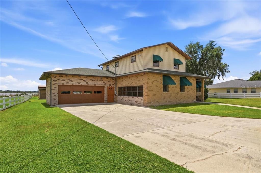 A two-story brick and siding house with a garage and a concrete driveway — 2731 STATE ROAD 557, LAKE ALFRED, FL
