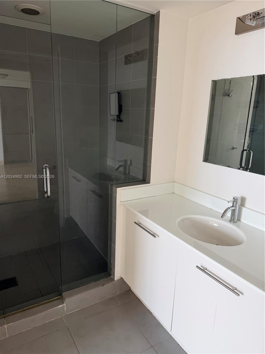 A bathroom features a glass-enclosed shower with gray tile and a white vanity cabinet — 92 SW 3rd St # 3909, Miami FL 33130, MIAMI, FL