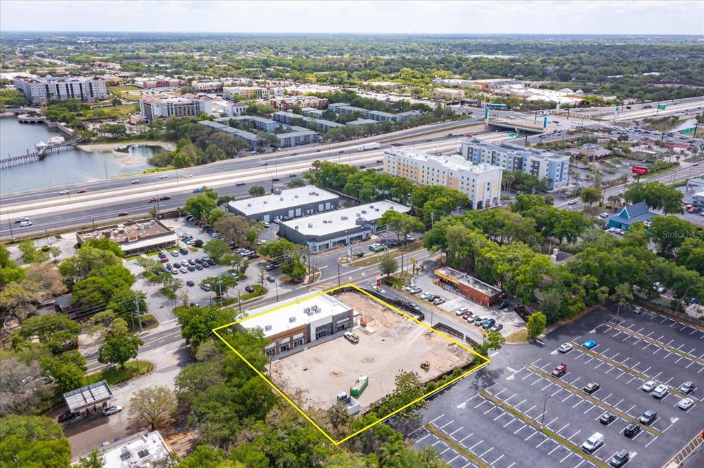An aerial view shows a commercial lot with a partially constructed building and parking area — 286 DOUGLAS AVENUE, ALTAMONTE SPRINGS, FL