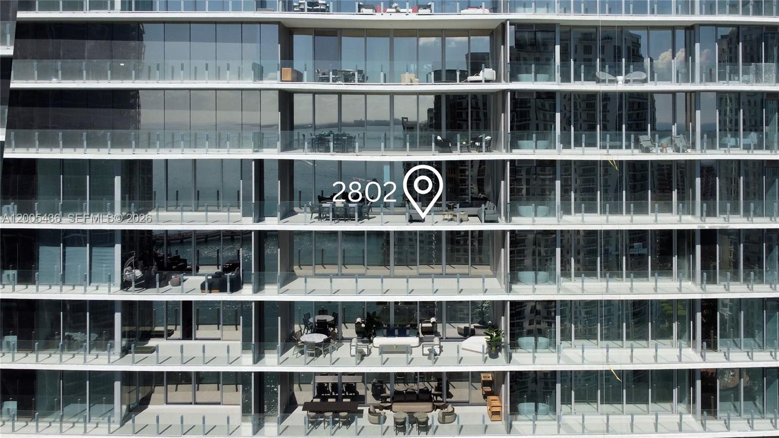An exterior view of a high-rise building featuring multiple levels of balconies with glass railings — 300 Biscayne Blvd Way # 2802, Miami FL 33131, MIAMI, FL