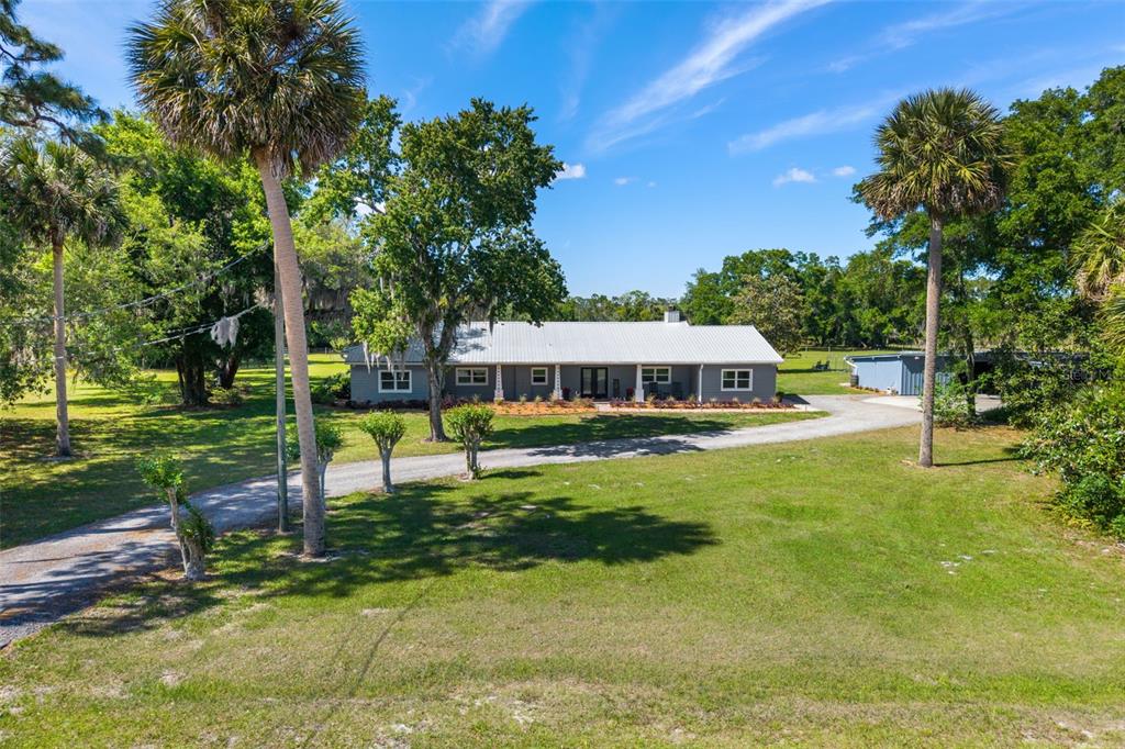 A single-story house with a metal roof sits on a large, grassy, tree-filled lot — 650 OLD MIMS ROAD, GENEVA, FL