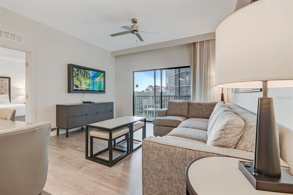 A living room features a gray sectional sofa, a coffee table, and a wall-mounted television — 14501 GROVE RESORT AVENUE UNIT 3706, WINTER GARDEN, FL