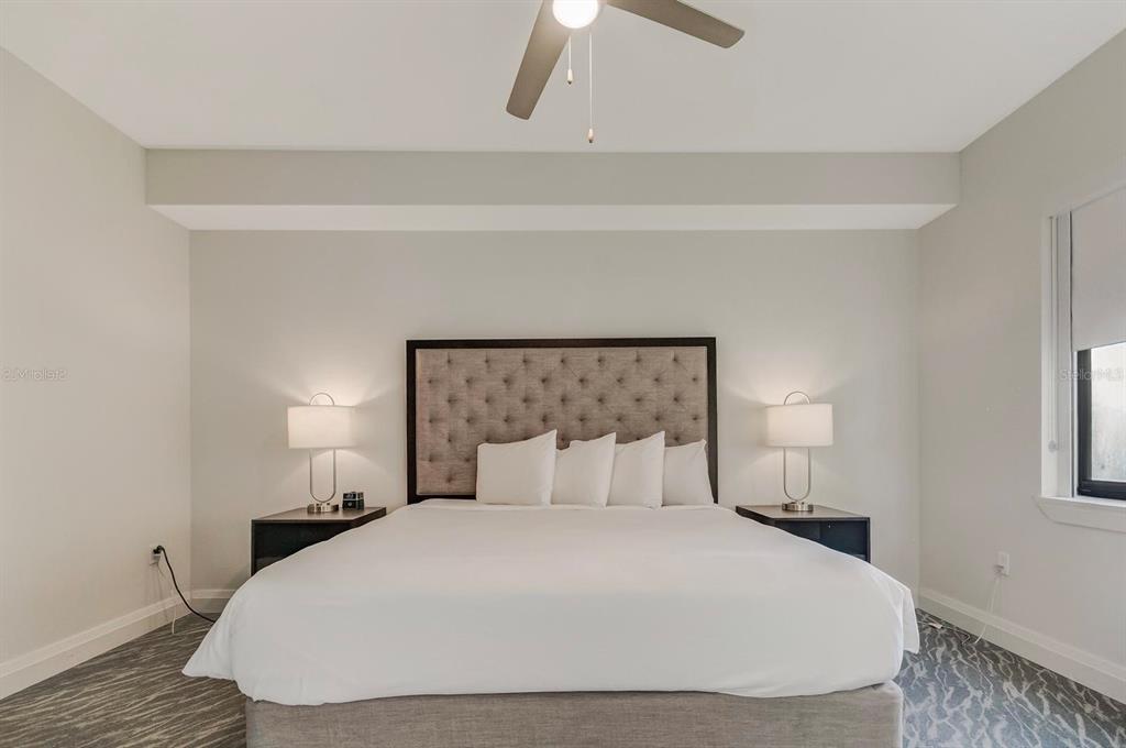 A bedroom features a tufted headboard, two bedside lamps, and a ceiling fan — 14501 GROVE RESORT AVENUE UNIT 3706, WINTER GARDEN, FL