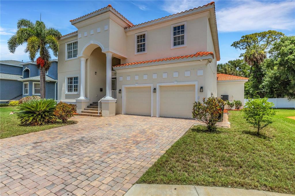 A two-story house with a paved driveway, two-car garage, and a palm tree in front — 3021 59TH AVENUE S, ST PETERSBURG, FL