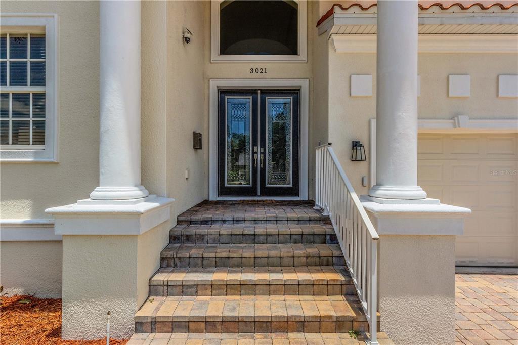 The front entrance features a double door with glass inserts, stone steps, and white columns — 3021 59TH AVENUE S, ST PETERSBURG, FL