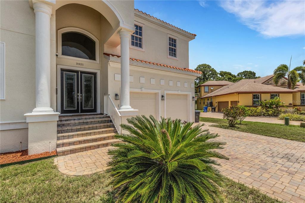 A two-story house with a paved driveway, a front porch, and a large palm plant — 3021 59TH AVENUE S, ST PETERSBURG, FL