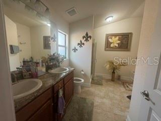 A bathroom features a wooden vanity with a sink, a toilet, and a walk-in shower — 12244 LEGACY BRIGHT STREET, RIVERVIEW, FL