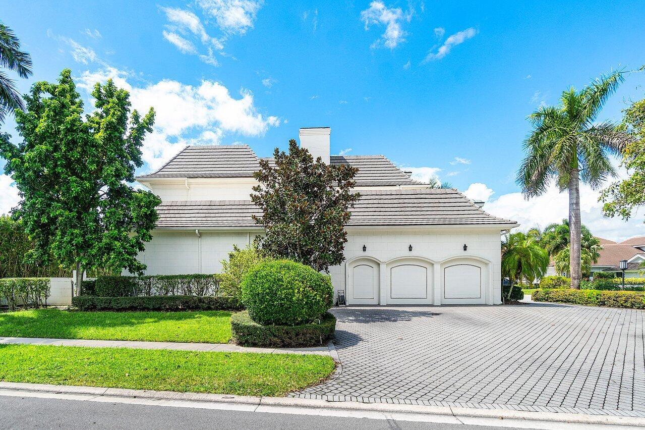 A white house with a three-car garage and a paved driveway under a blue sky — 7172 Valencia Drive, Boca Raton FL 33433, BOCA RATON, FL