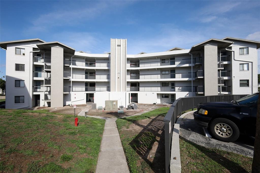 A multi-story apartment building with a curved facade, balconies, and a sidewalk leading to entrances — 1068 LOTUS PARKWAY UNIT 836, ALTAMONTE SPRINGS, FL