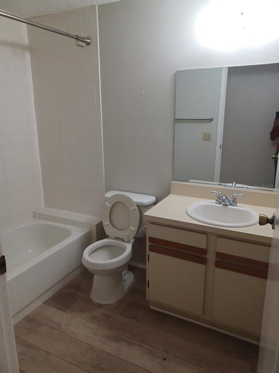 A bathroom features a white bathtub, a toilet, and a vanity with a single sink — 127 CAMPHOR CIRCLE UNIT D, OLDSMAR, FL