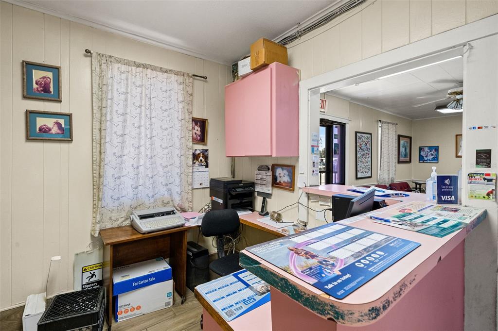 A reception area features a pink service counter, wood-paneled walls, and a window with curtains — 6603 N FLORIDA AVENUE, TAMPA, FL