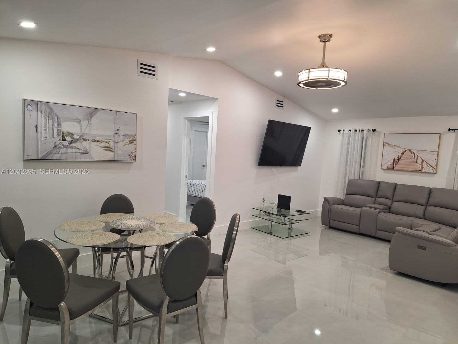 A dining area with a glass table and a living room with a gray sofa — 4440 SW 14 pl, Cape Coral FL 339914, CAPE CORAL, FL