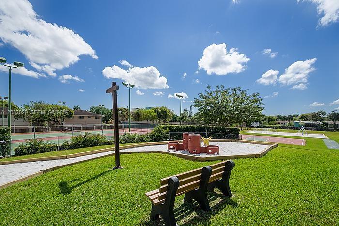 A park features a playground with a sandbox, a wooden bench, and tennis courts — 7956 Camino Cir # A4, Miami FL 33143, MIAMI, FL
